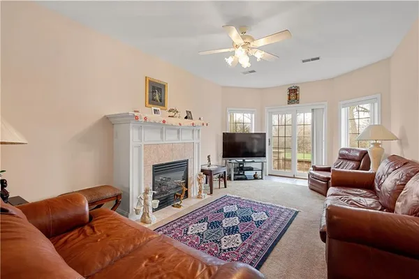 a living room with furniture a fireplace and a chandelier