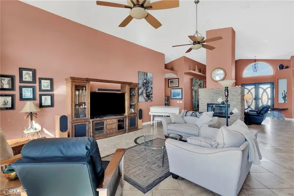 a living room with furniture kitchen view and a chandelier