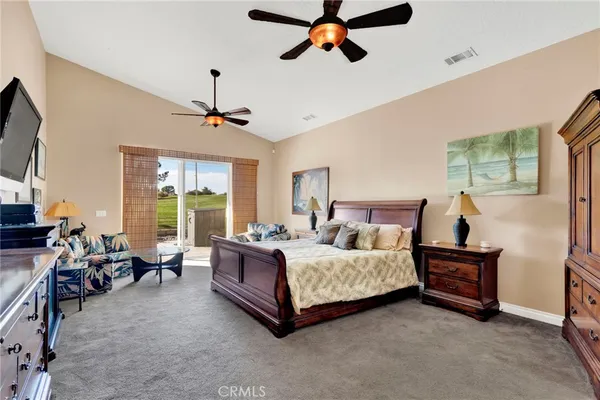 a bedroom with a bed couch and a flat screen tv