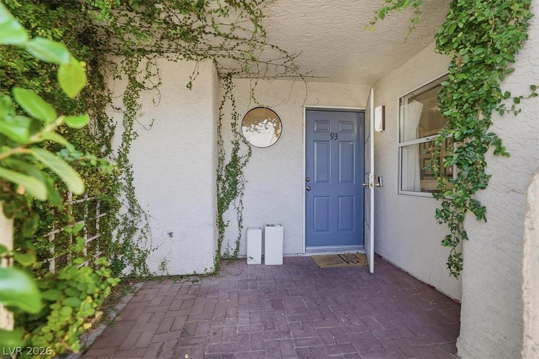 6250 West Flamingo Road, Unit 93 Las Vegas, NV 89103 - Photo 6 of 38 The inviting entrance features brick pavers and lush greenery, leading to a charming doorway.