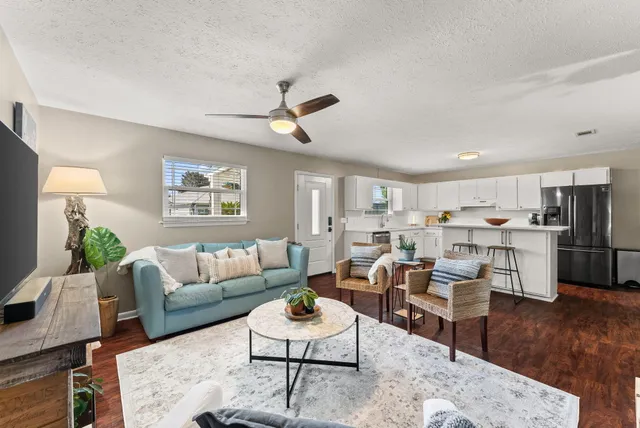 a living room with furniture kitchen view and a table