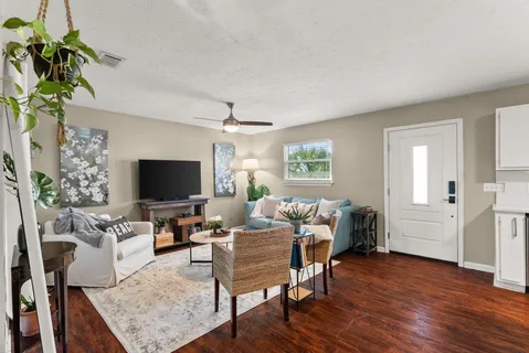 a living room with furniture and a wooden floor