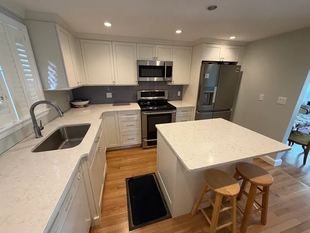 a kitchen with stainless steel appliances a stove a sink a microwave and a refrigerator