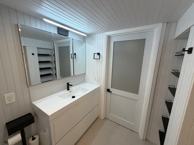 a bathroom with a sink a toilet and shower