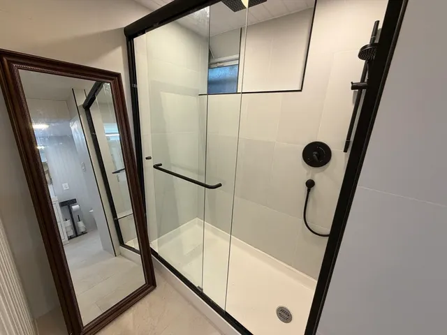 a bathroom with a shower and a mirror