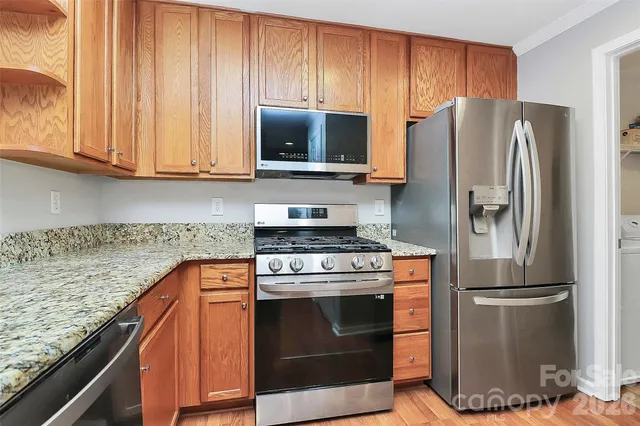 a kitchen with stainless steel appliances granite countertop a refrigerator stove and microwave