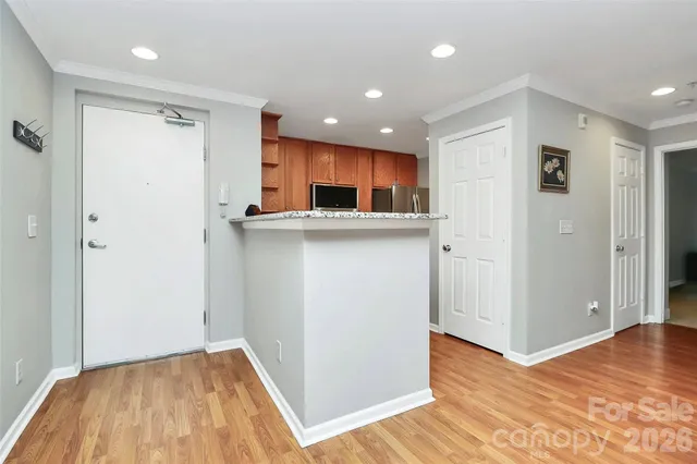 a view of kitchen with stainless steel appliances granite countertop cabinets and wooden floor
