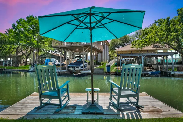 a patio with water fountain table and chairs under an umbrella