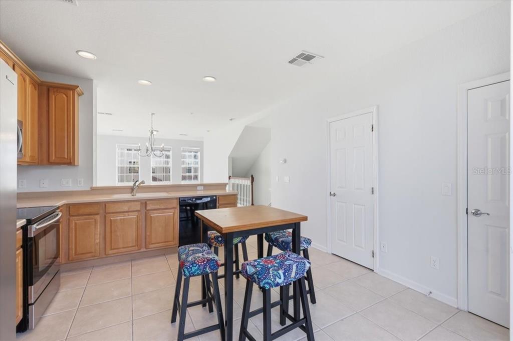 5026 Tideview Circle, Unit 12 Orlando, FL 32819 - Photo 14 of 41 a kitchen with a table chairs sink and cabinets