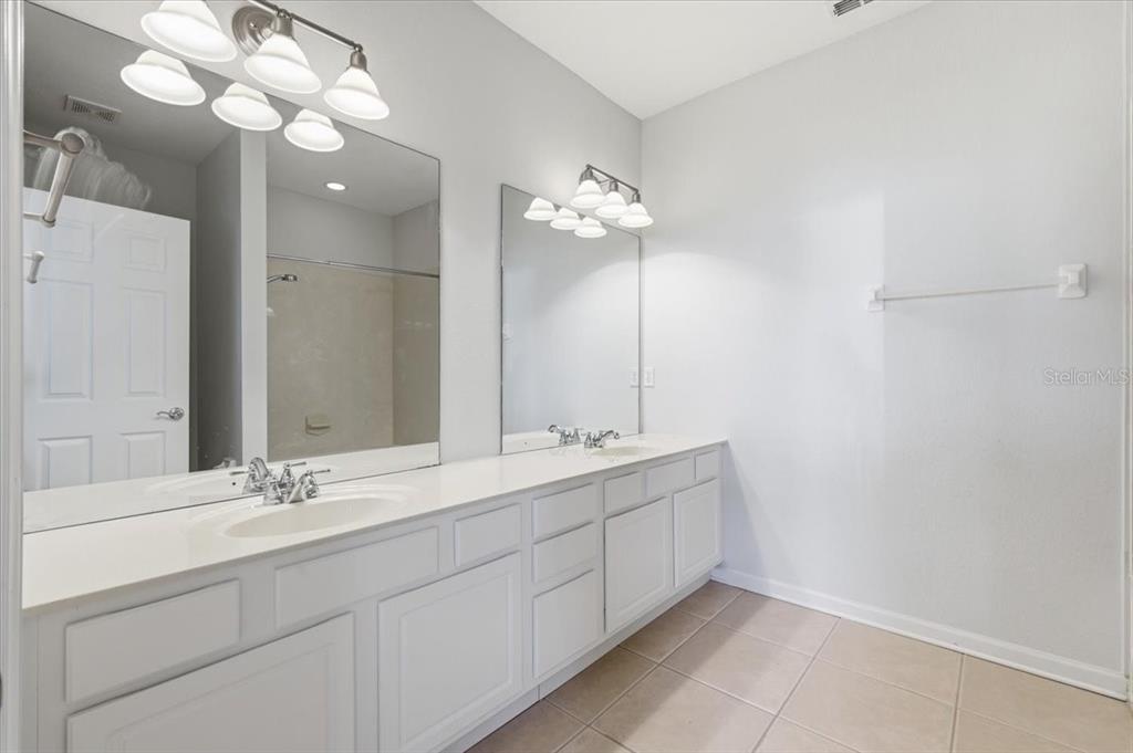 5026 Tideview Circle, Unit 12 Orlando, FL 32819 - Photo 30 of 41 a bathroom with a double vanity sink and a mirror