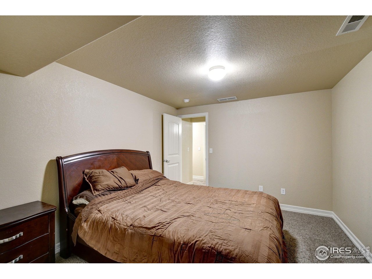 6743 Sequoia Street Frederick, CO 80530 - Photo 26 of 39 a bedroom with a bed and a night stand