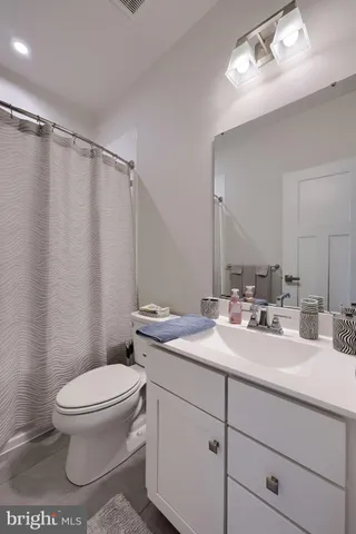a bathroom with a sink vanity mirror and toilet