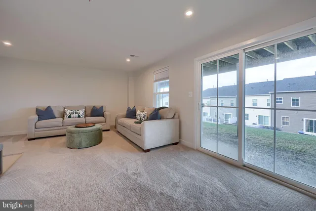 a living room with furniture and a floor to ceiling window