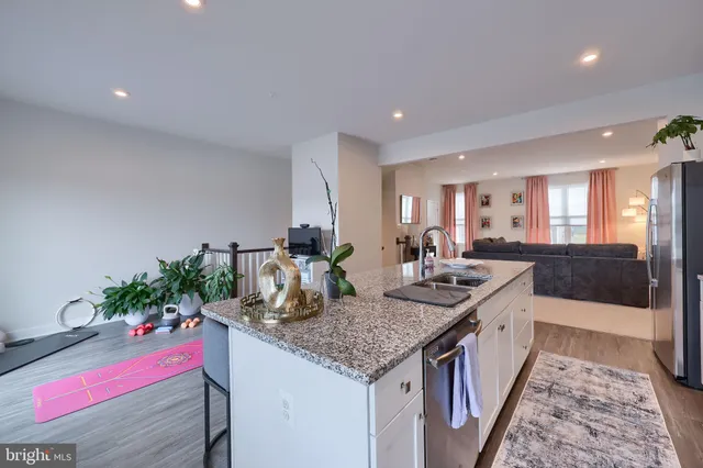 a kitchen with granite countertop kitchen island stainless steel appliances a sink and cabinets