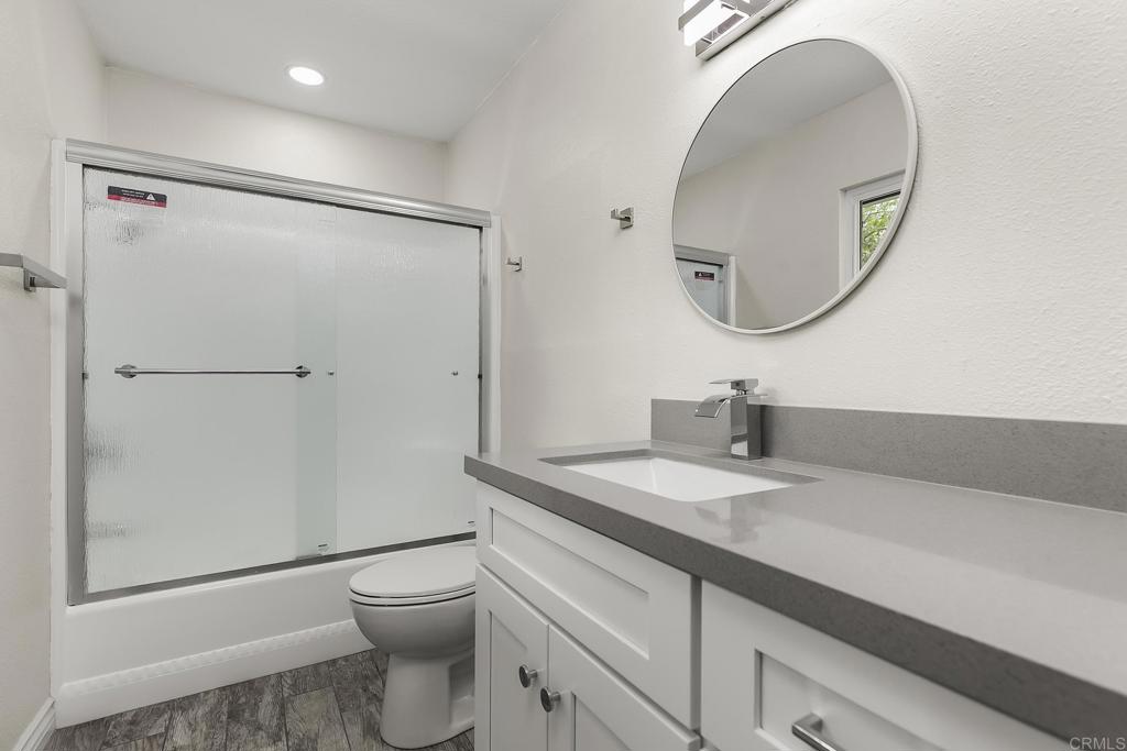 13500 Jamul Drive Jamul, CA 91935 - Photo 22 of 39 a bathroom with a granite countertop sink toilet a mirror and a shower