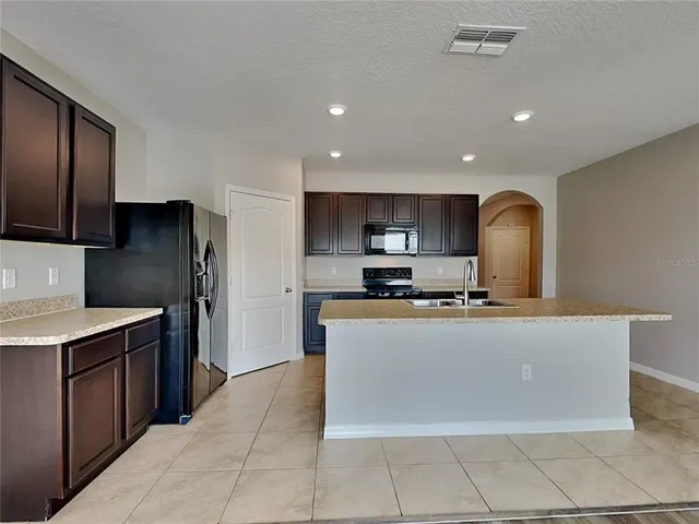 a kitchen with stainless steel appliances granite countertop a refrigerator and a stove top oven
