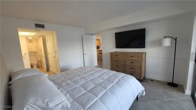 a bedroom with a bed and a television