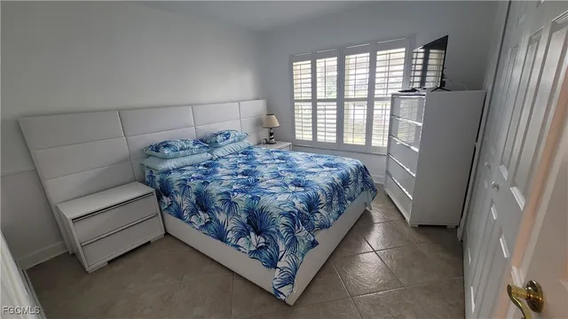 a bed sitting in a bedroom next to a window