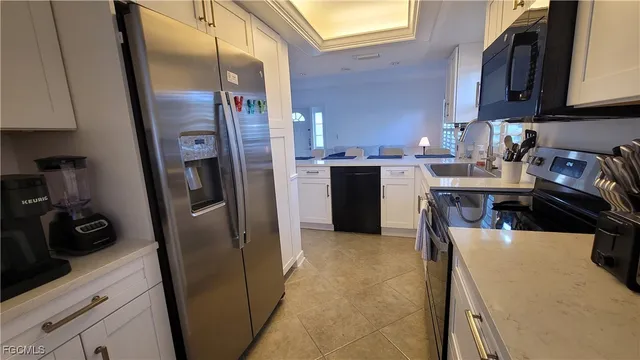 a kitchen with stainless steel appliances granite countertop a refrigerator a stove and a sink with wooden floor