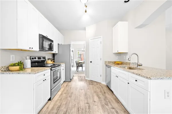 a kitchen with stainless steel appliances granite countertop a stove a refrigerator and a microwave