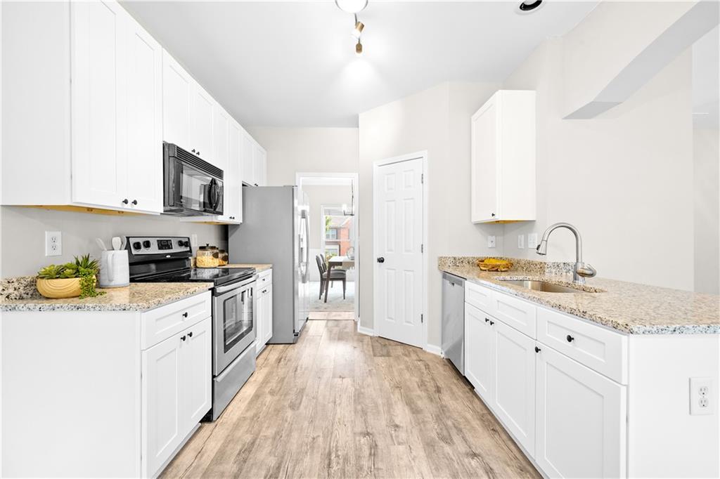 3720 Brookefall Landing Suwanee, GA 30024 - Photo 17 of 41 a kitchen with a sink a stove and cabinets