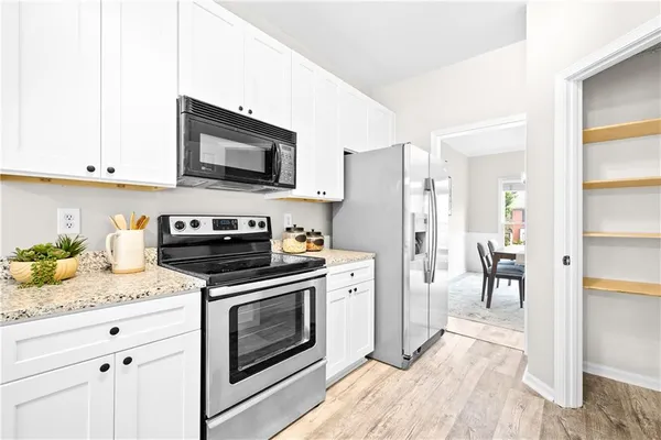 a view of a kitchen area with furniture and wooden floor