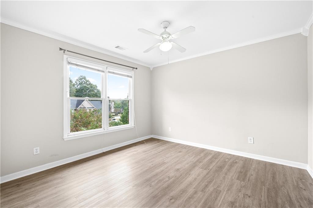 3720 Brookefall Landing Suwanee, GA 30024 - Photo 30 of 41 an empty room with wooden floor chandelier fan and windows