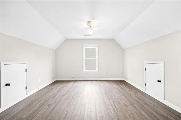 a view of a room with wooden floor and a ceiling fan