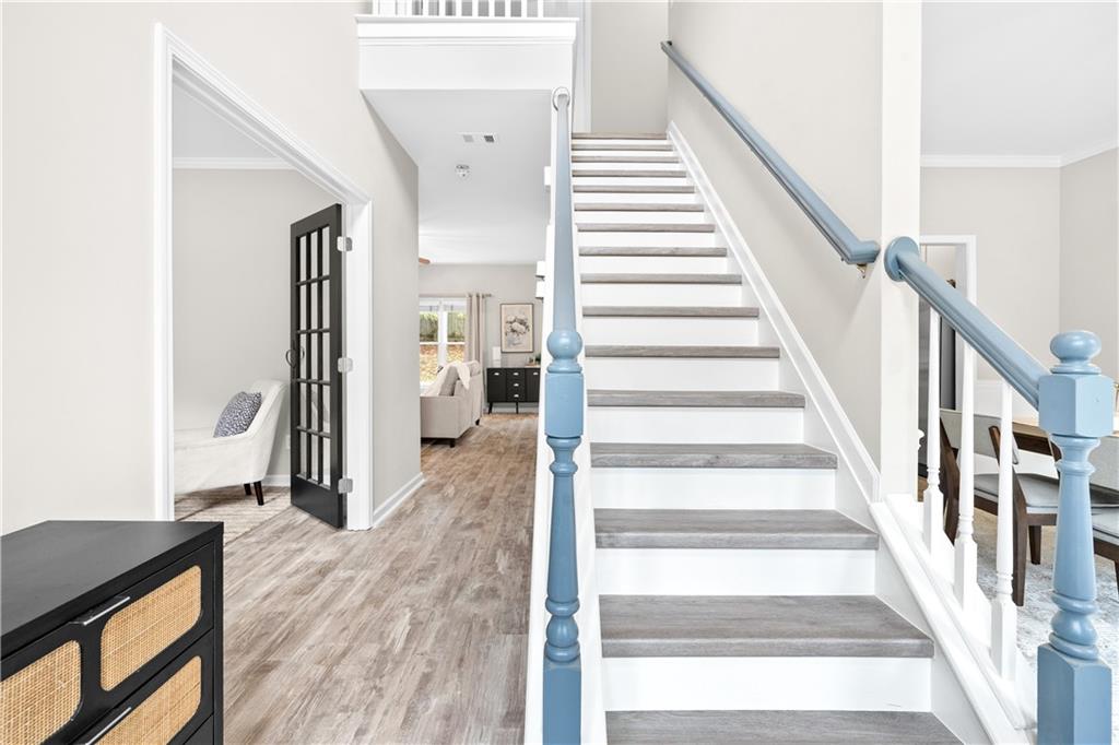 3720 Brookefall Landing Suwanee, GA 30024 - Photo 5 of 41 a view of a hallway to a livingroom with wooden floor and staircase