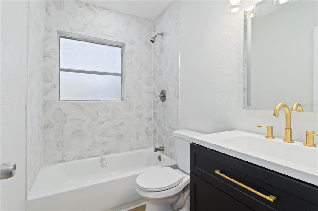 5337 60th Street North Kenneth City, FL 33709 - Photo 15 of 29 a bathroom with a sink a toilet and shower