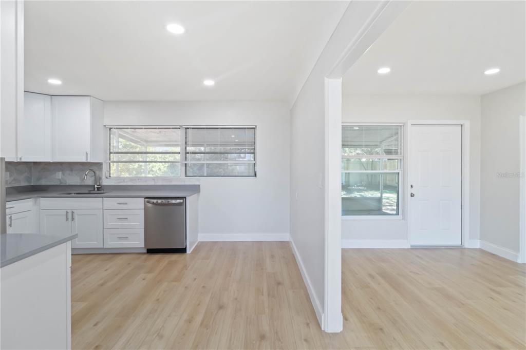 5337 60th Street North Kenneth City, FL 33709 - Photo 6 of 29 a kitchen with stainless steel appliances granite countertop a stove a sink and white cabinets with wooden floor