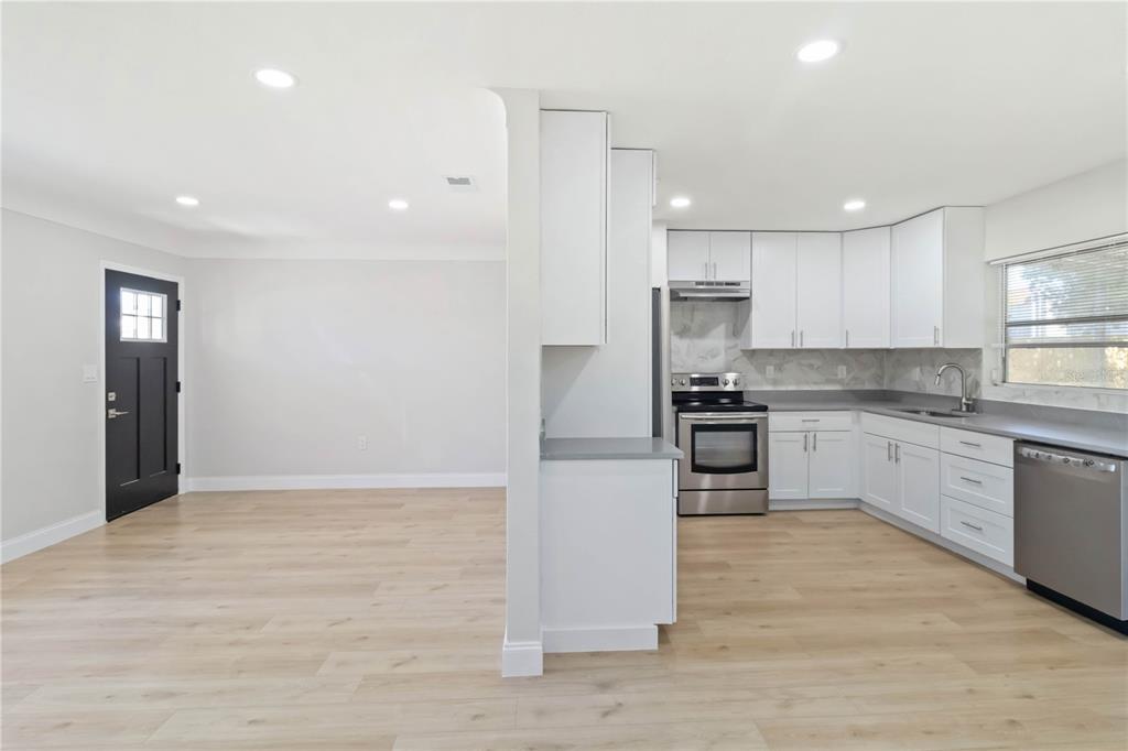 5337 60th Street North Kenneth City, FL 33709 - Photo 7 of 29 a large kitchen with kitchen island a sink stainless steel appliances and cabinets