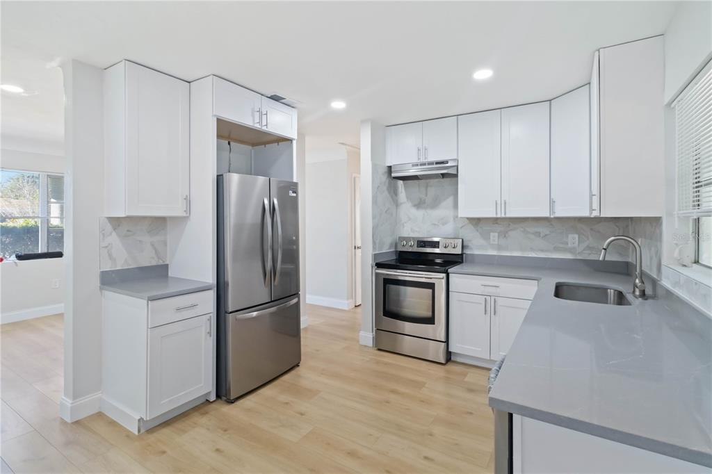 5337 60th Street North Kenneth City, FL 33709 - Photo 10 of 29 a kitchen with a refrigerator and a sink
