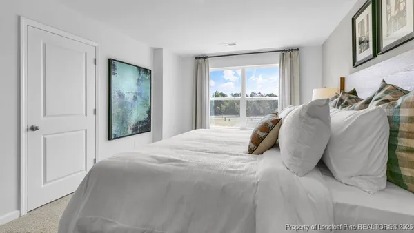 a large bed sitting in a bedroom next to a window