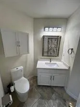 a bathroom with a toilet sink and mirror