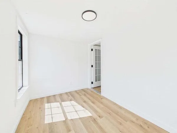 a view of a room with wooden floor and mirror