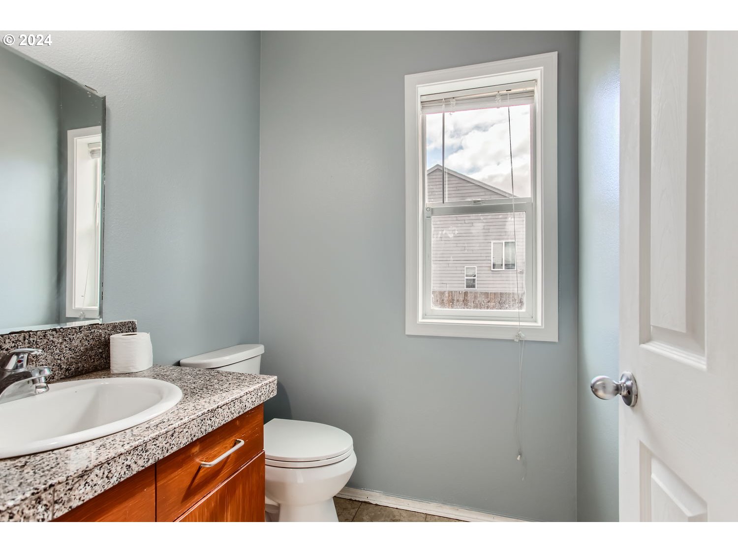 11405 Southeast Clinton Street Portland, OR 97266 - Photo 14 of 29 a bathroom with a granite countertop sink mirror vanity and a toilet