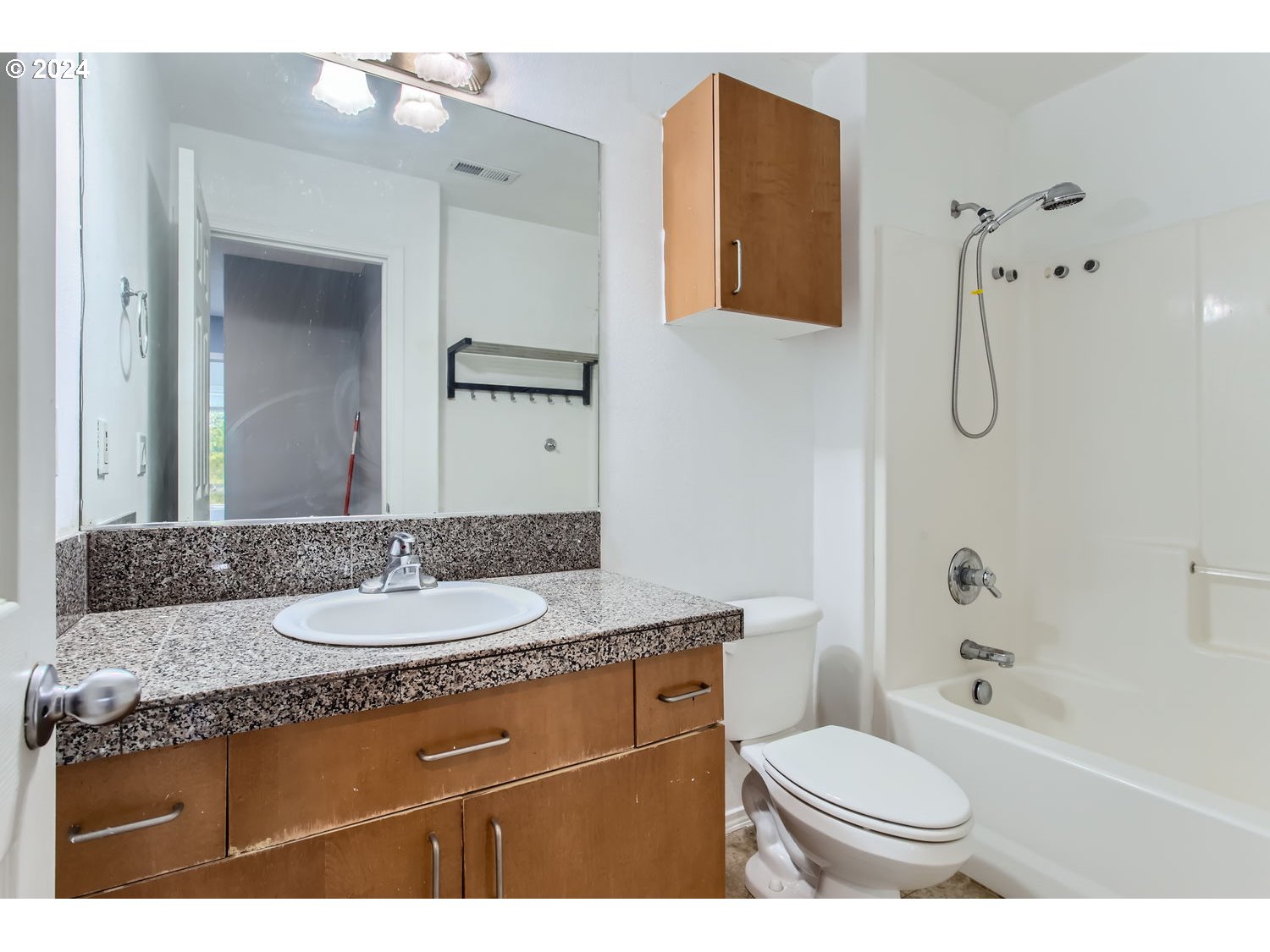 11405 Southeast Clinton Street Portland, OR 97266 - Photo 23 of 29 a bathroom with a granite countertop sink toilet a mirror and bathtub