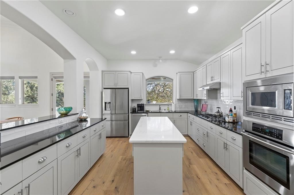 a large kitchen with stainless steel appliances lots of counter space sink and a refrigerator