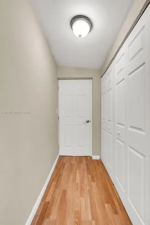 a view of a room with wooden floor and white walls