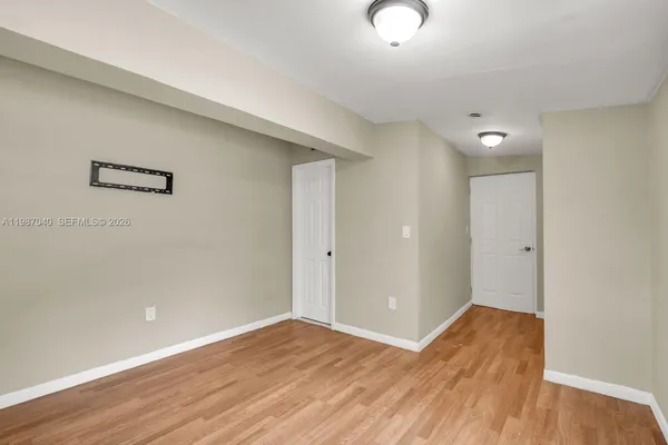 a view of an empty room with wooden floor