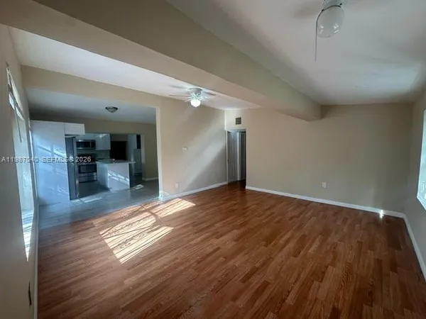 a view of empty room with wooden floor
