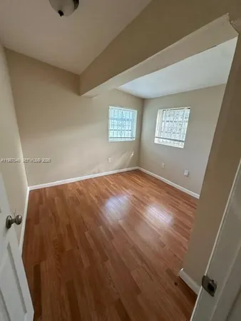 a view of a room with wooden floor and windows