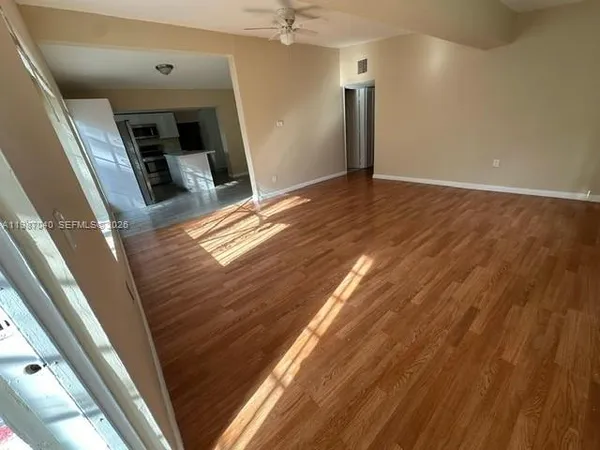 a view of an empty room with wooden floor