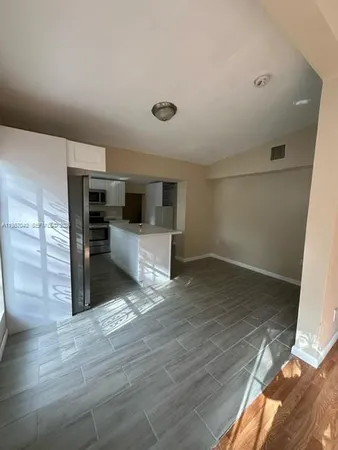 a view of kitchen with sink microwave and refrigerator