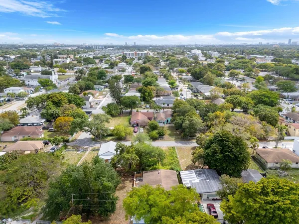 an aerial view of residential houses with outdoor space and trees