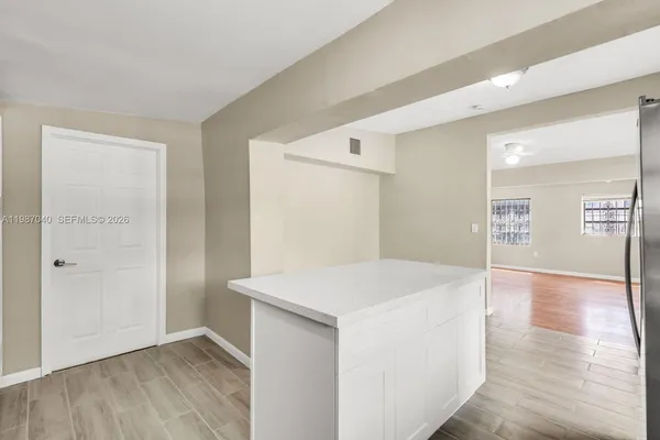 a view of empty room with wooden floor