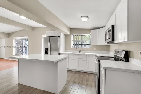 a kitchen with stainless steel appliances granite countertop a sink and cabinets