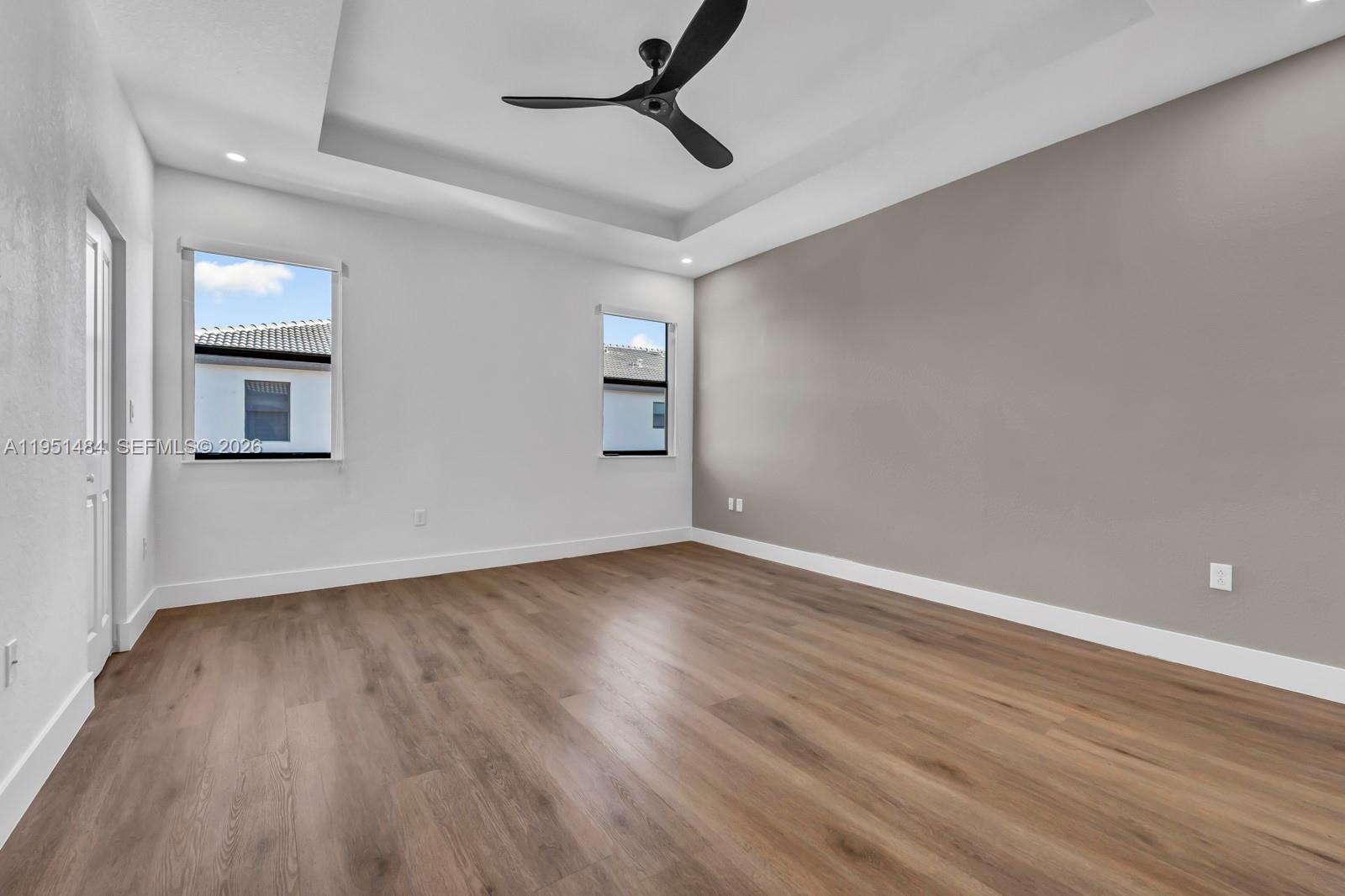 13067 Southwest 286th Street, Unit 13067 Homestead, FL 33033 - Photo 14 of 37 an empty room with wooden floor and windows