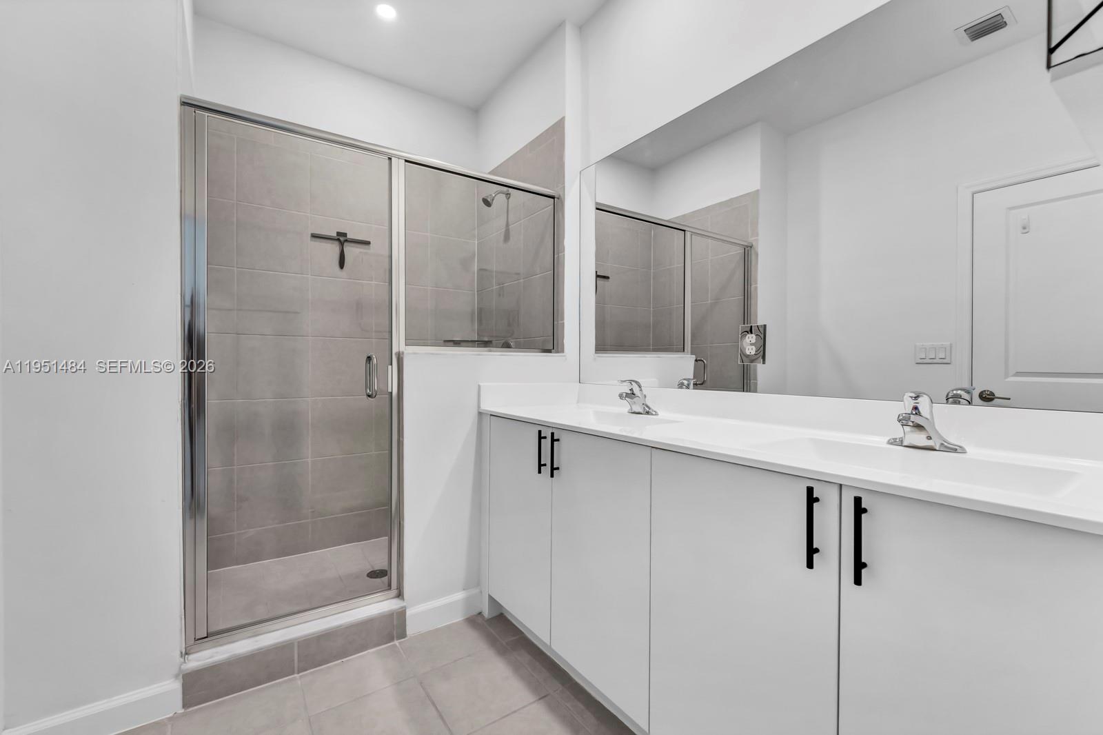 13067 Southwest 286th Street, Unit 13067 Homestead, FL 33033 - Photo 16 of 37 a bathroom with a double vanity sink mirror and shower